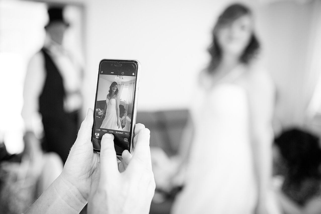 Das Brautkleid samt Braut auf dem Handy