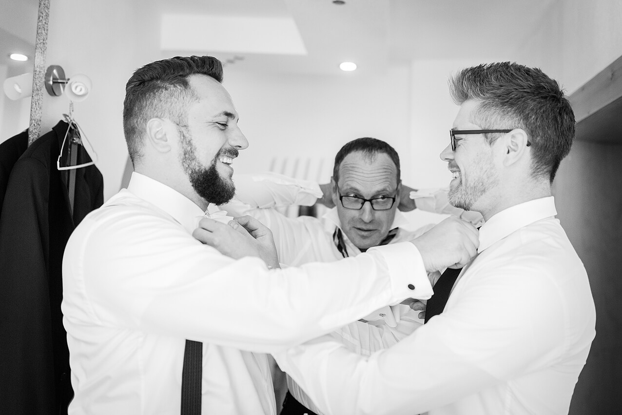 Bräutigam und Trauzeuge binden sich gegenseitig die Krawatte