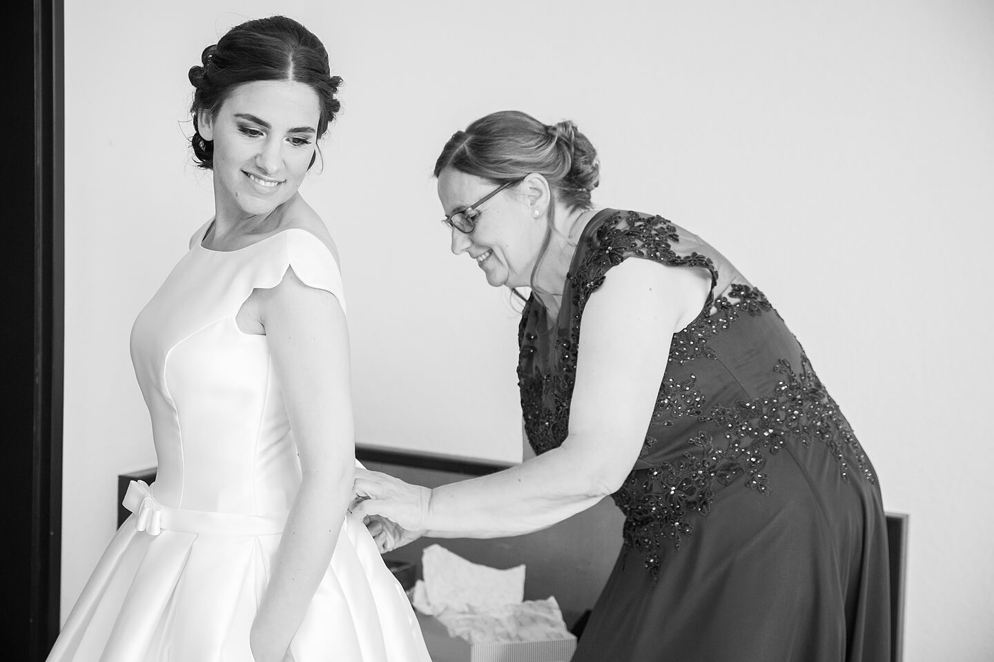 Brautmutter schnürt das Brautkleid