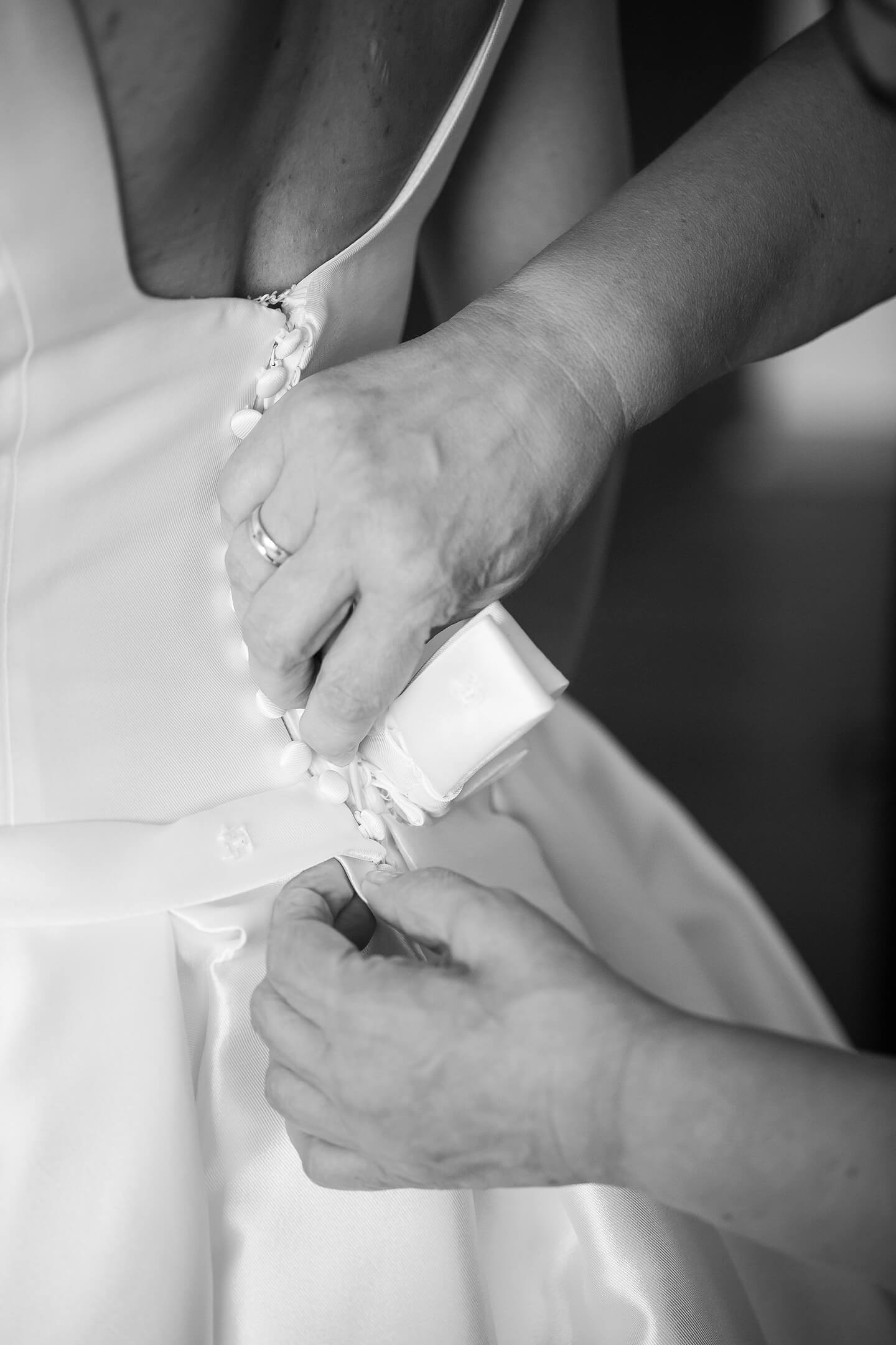 Detailfoto vom Schnueren des Brautkleids