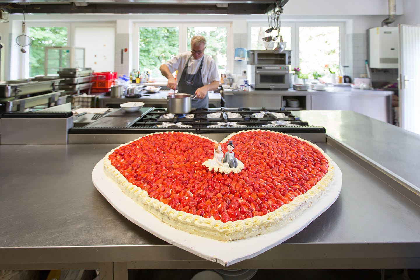 Große Erdbeer-Hochzeitstorte in der Küche der Hochzeitslocation Westerhof