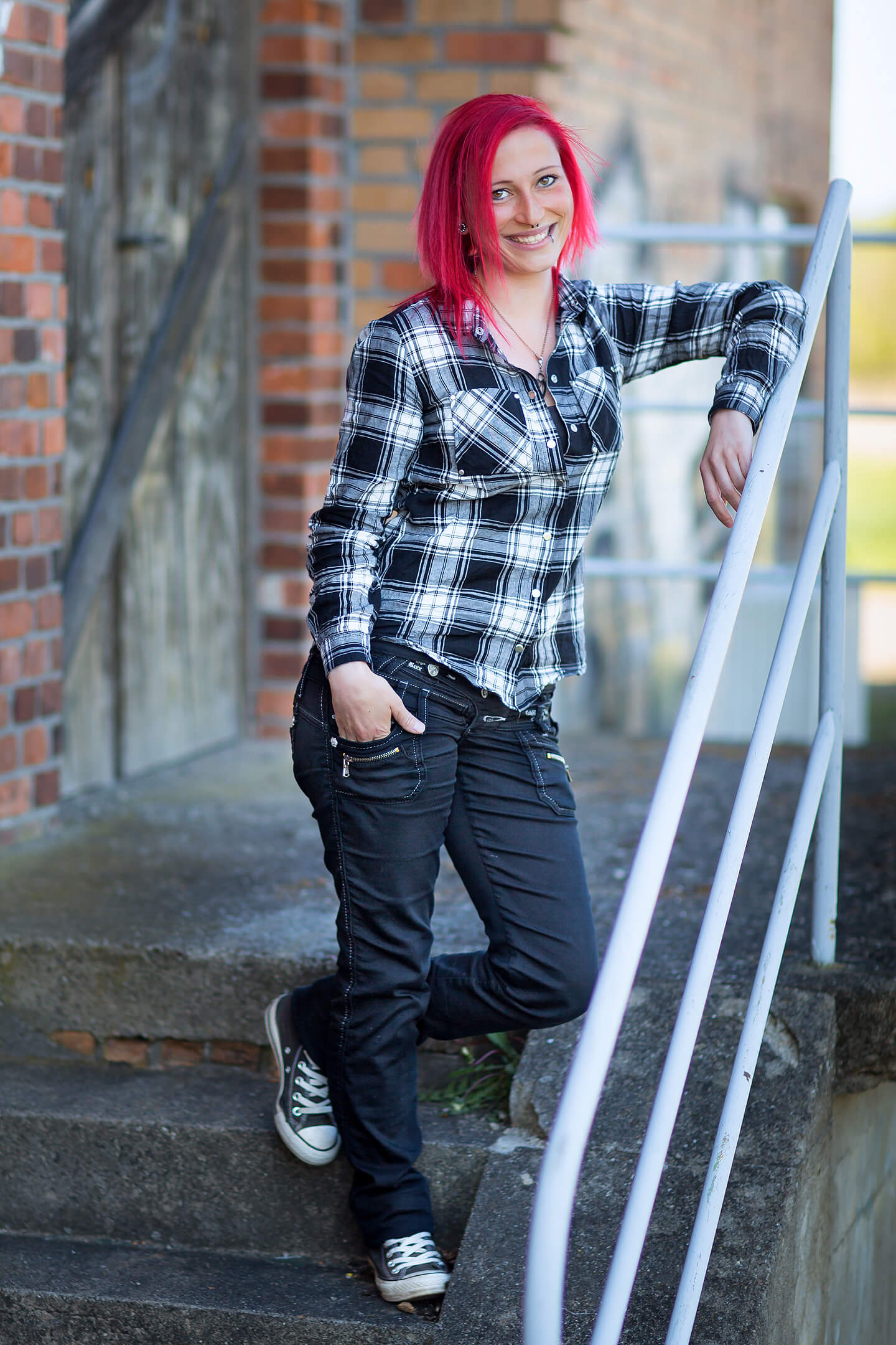 Frau mit knallroten Haaren bei urbanem Portraitshooting