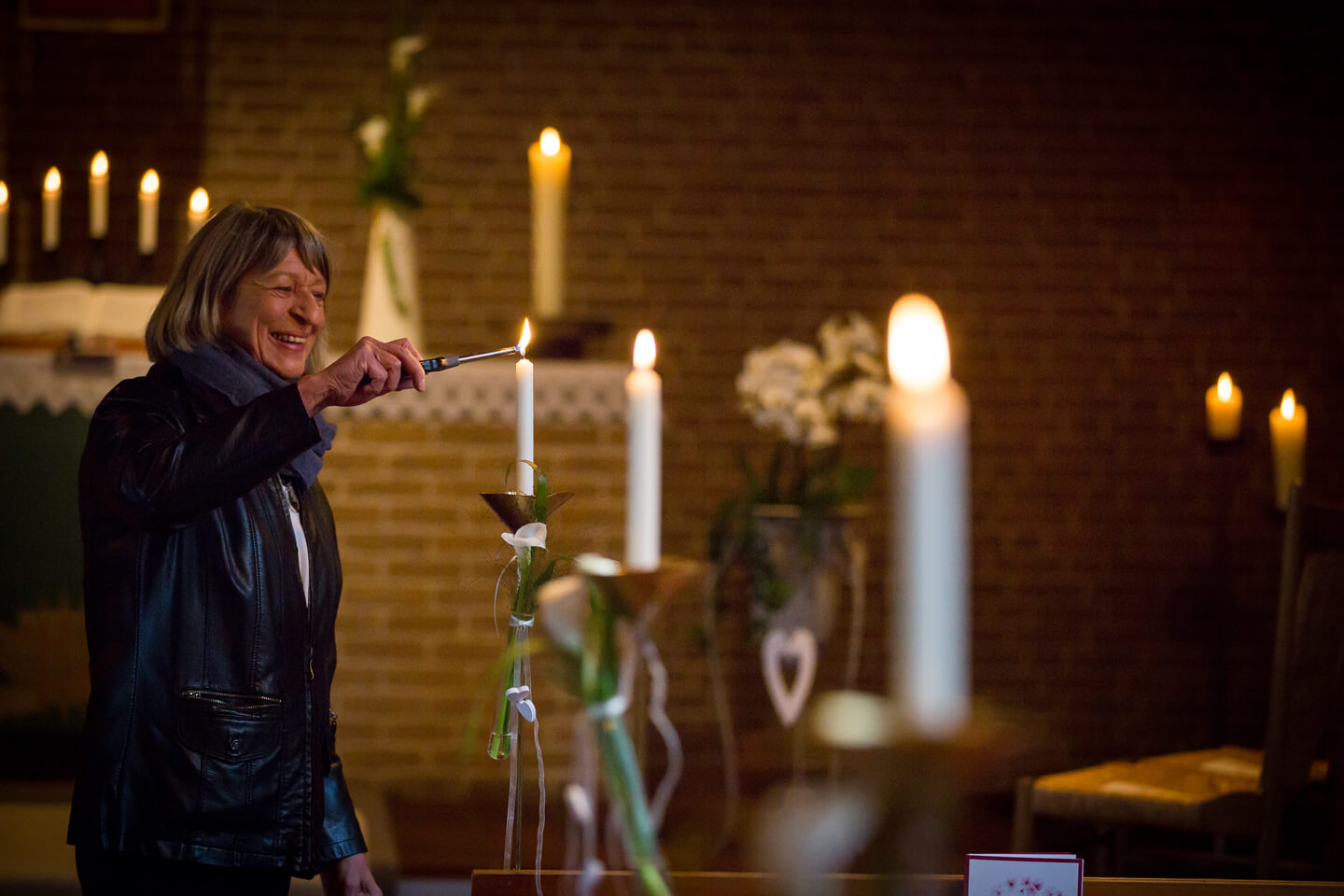 Küsterin zündet die Kerzen vor der kirchlichen Trauung an