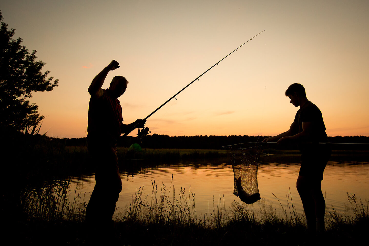 Angelfoto zwei erfolgreicher Angler im Sonnenuntergang