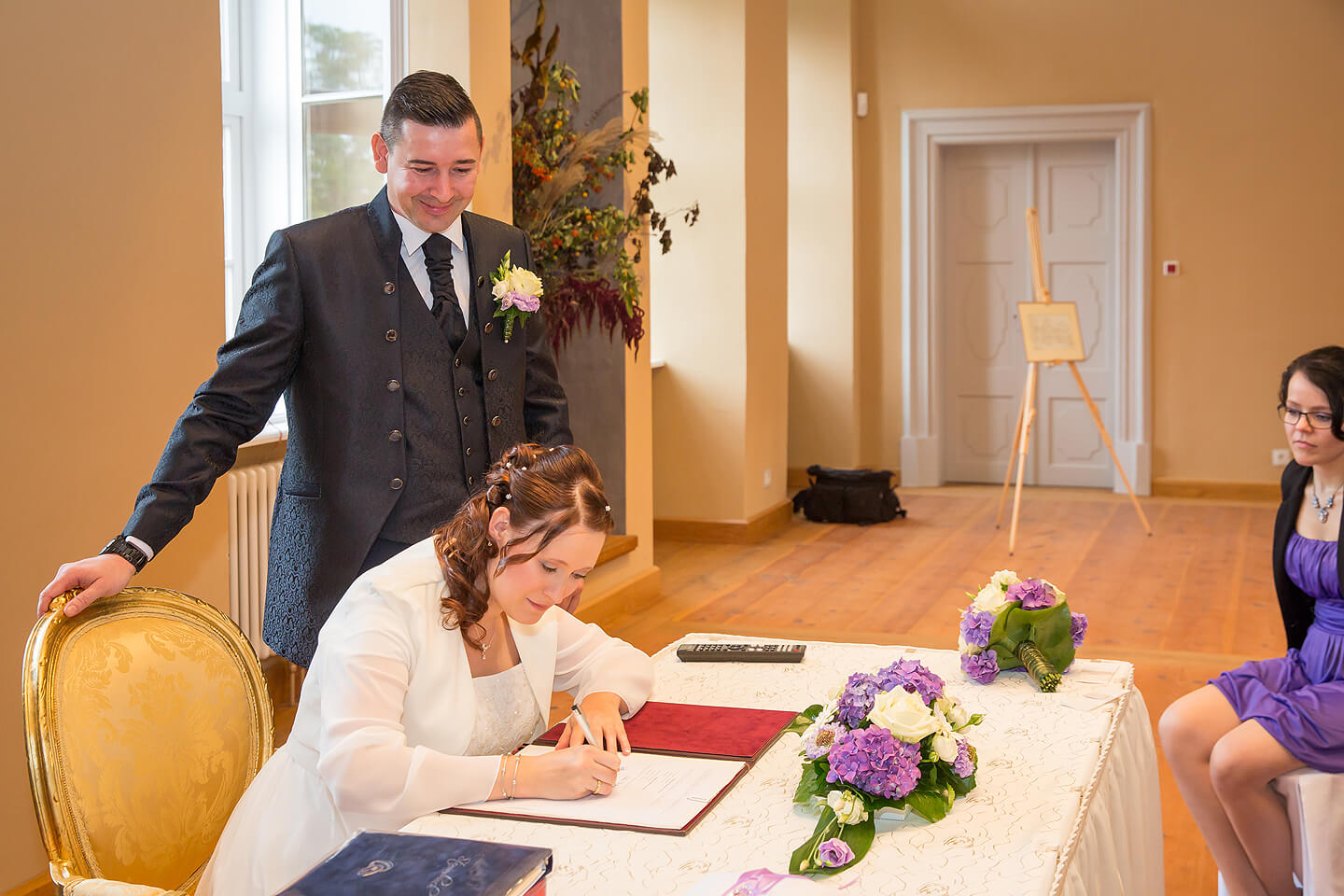 Braut leistet Unterschrift im Standesamt