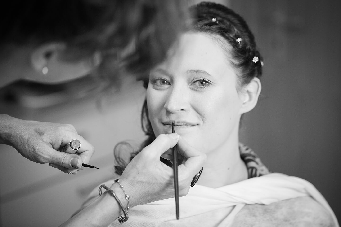 Braut wird von Visagistin geschminkt