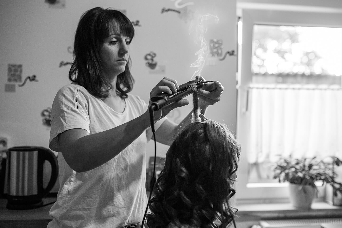 Braut bei den morgendlichen Vorbereitungen mit der Friseurin