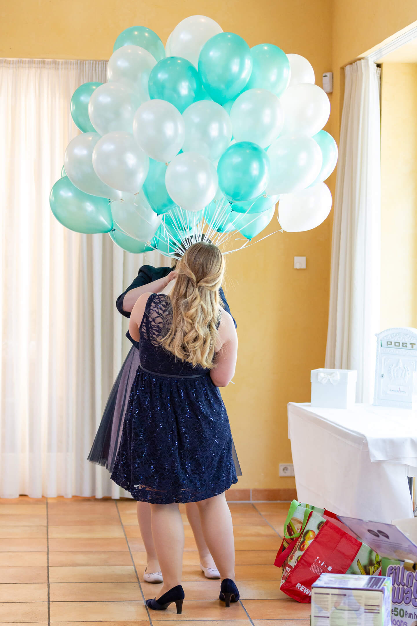 Helfende Hände, die ich während einer Hochzeitsreportage beim Vorbereiten von Ballons fotografiert habe