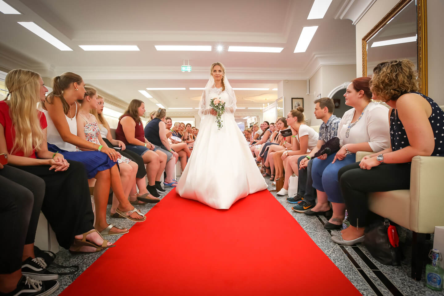 Besucherinnen der Hochzeitsmodenschau am Rande des Laufstegs
