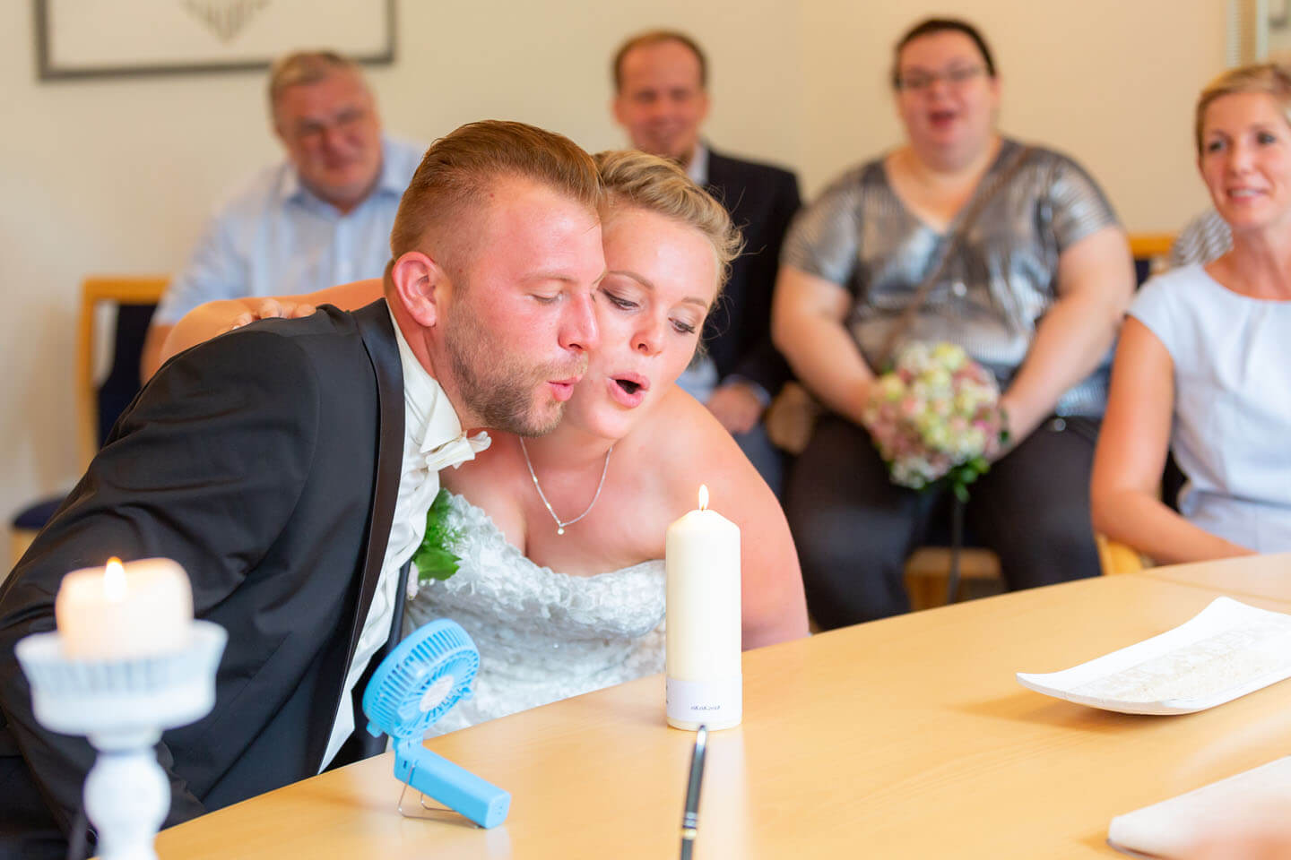 Hochzeitspaar pustet gemeinsam eine Kerze aus