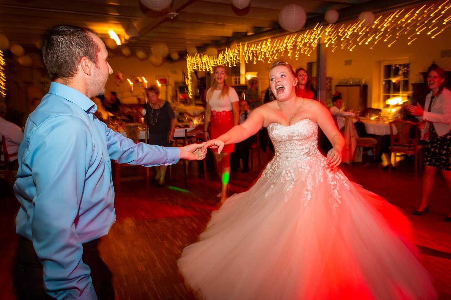 Ausgelassene Stimmung bei dieser Hochzeitsreportage. Braut tanzt mit Hochzeitsgast.