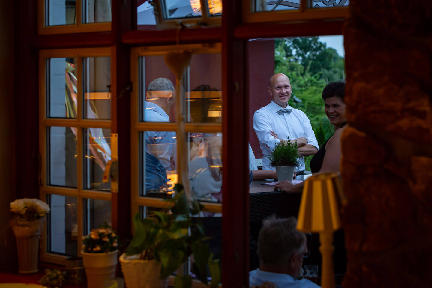 Perspektiven sind in der Hochzeitsfotografie wichtig! Durch offenstehendes Fenster fotografierte Gaeste