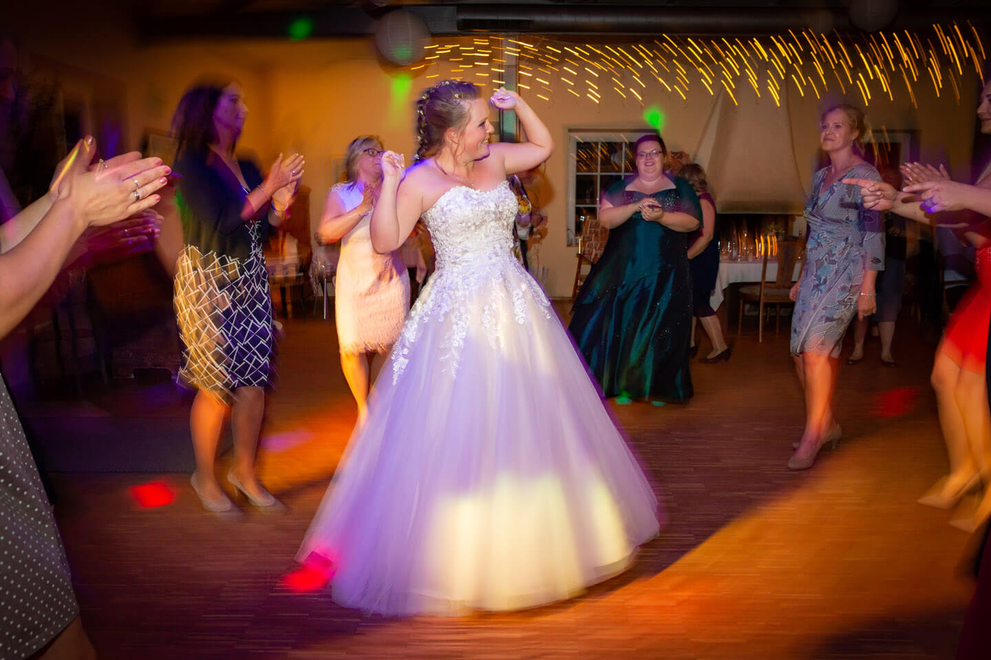 Braut tanzt umringt von ihren Freundinnen.