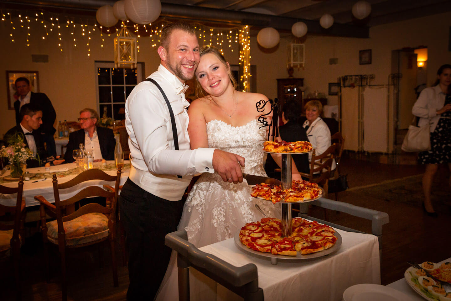 Hochzeitspaar schneidet Hochzeitspizza um Mitternacht an.
