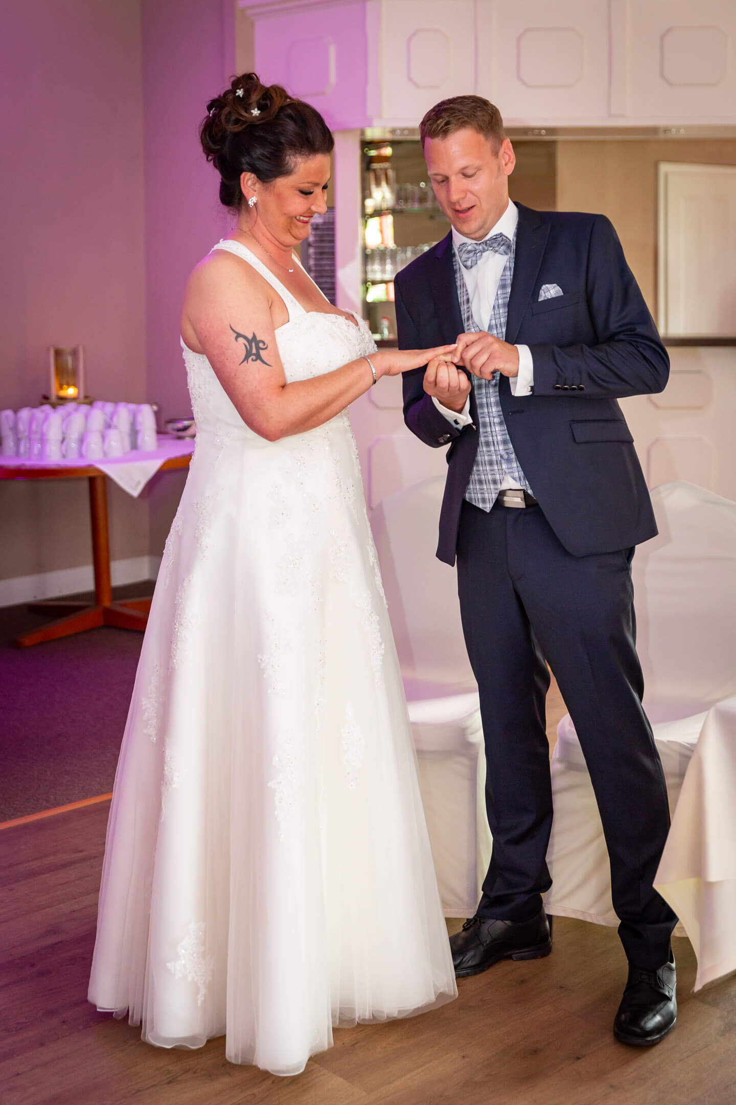 Bräutigam steckt seiner Frau bei freier Trauung den Ehering auf.