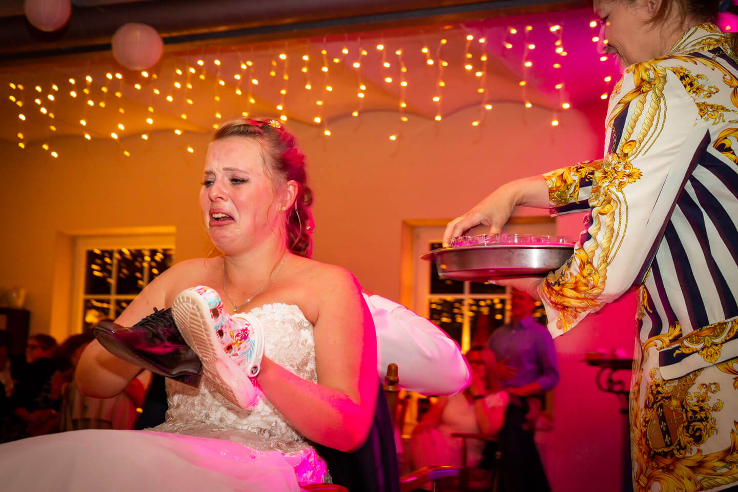 genau im richtigen Moment auf den Auslöser gedrückt: Braut verzieht das Gesicht, nachdem sie beim Schuhspiel einen Kurzen getrunken hat.
