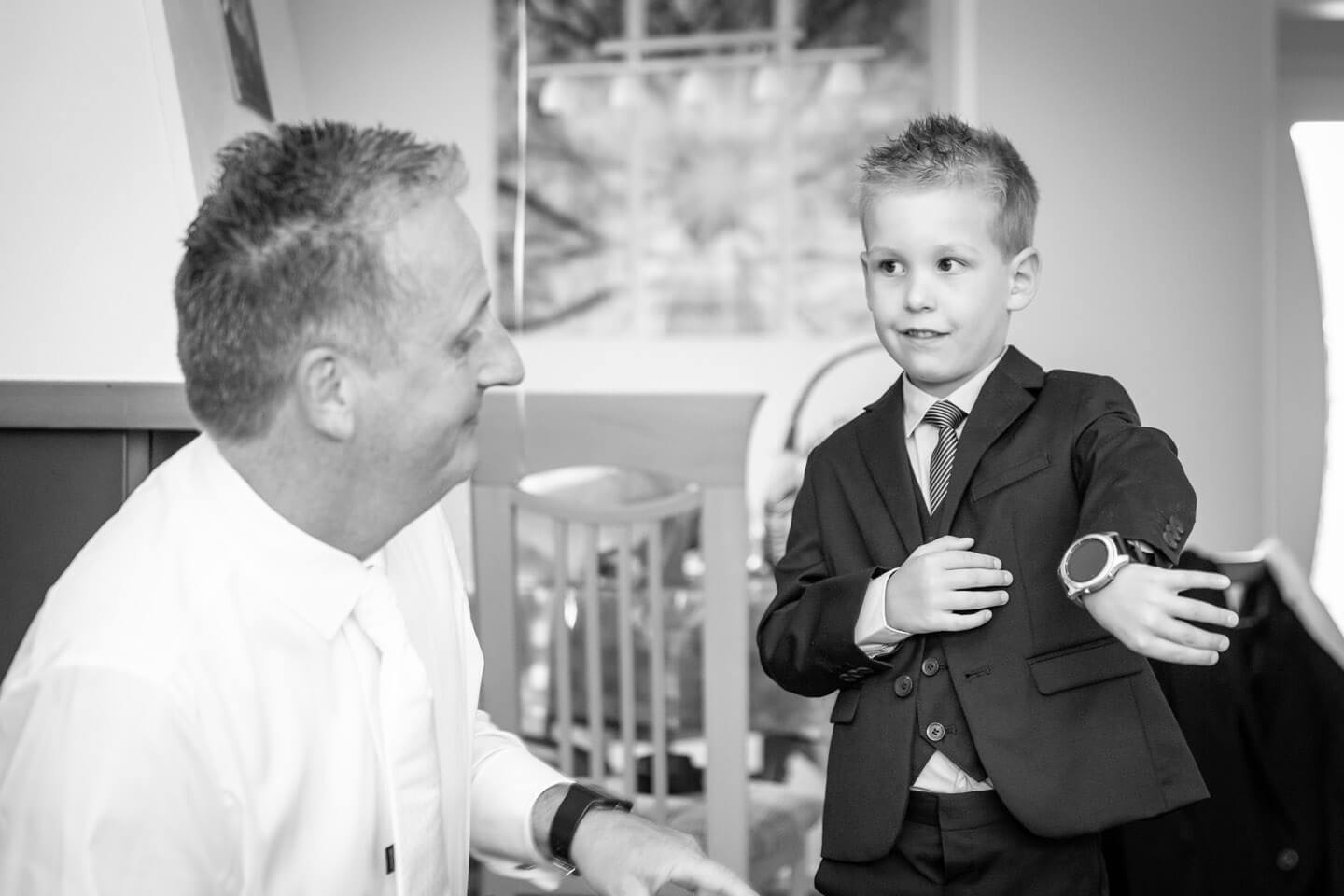 Sohn zeigt bei einer Hochzeitsreportage seinem Vater die Uhrzeit