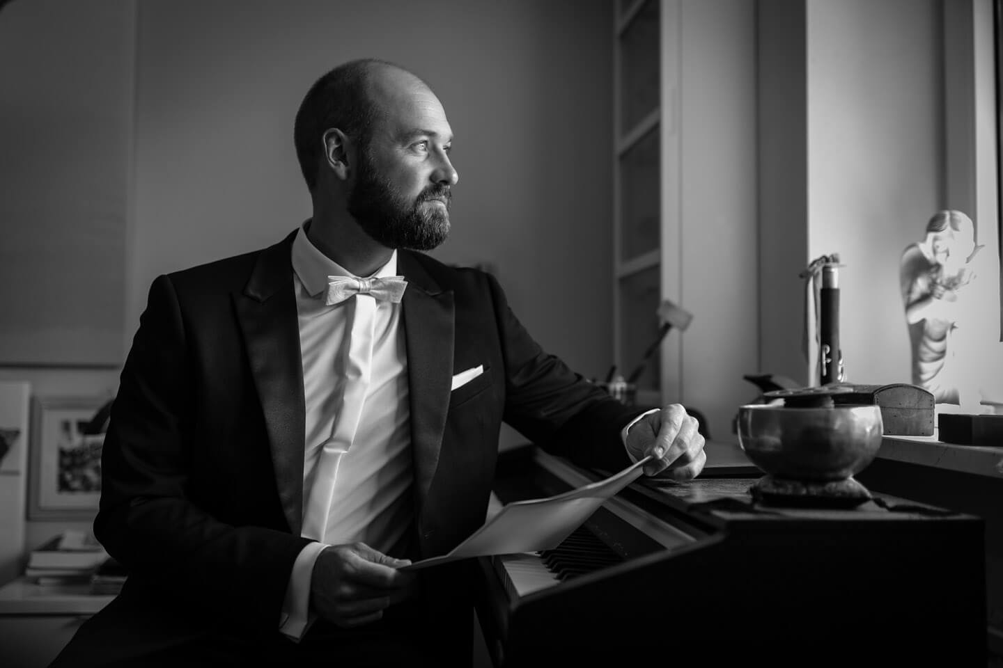 Bräutigam blickt im Schummerlicht aus dem Fenster