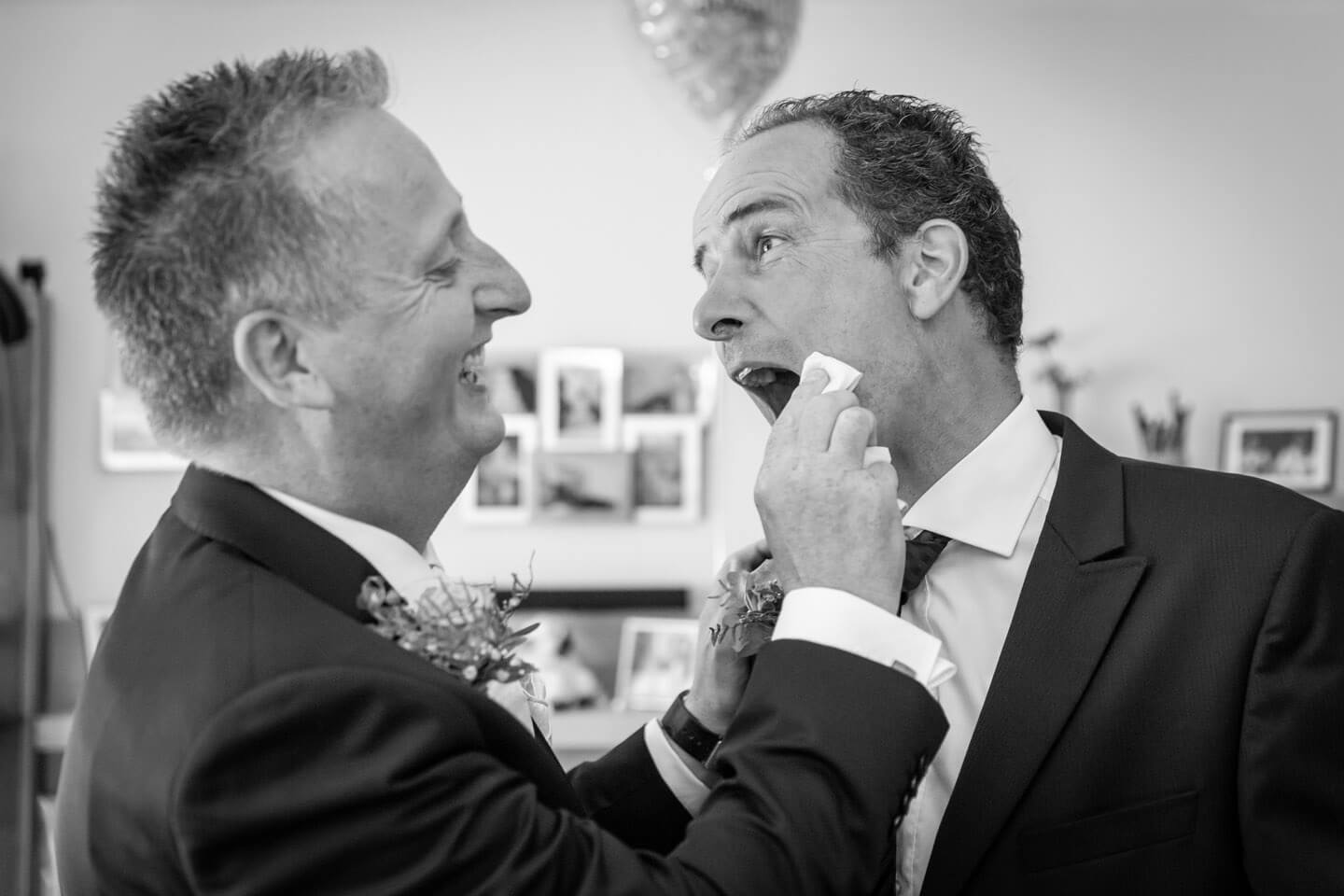 Braeutigam tupft seinem Trauzeugen den Mundwinkel ab