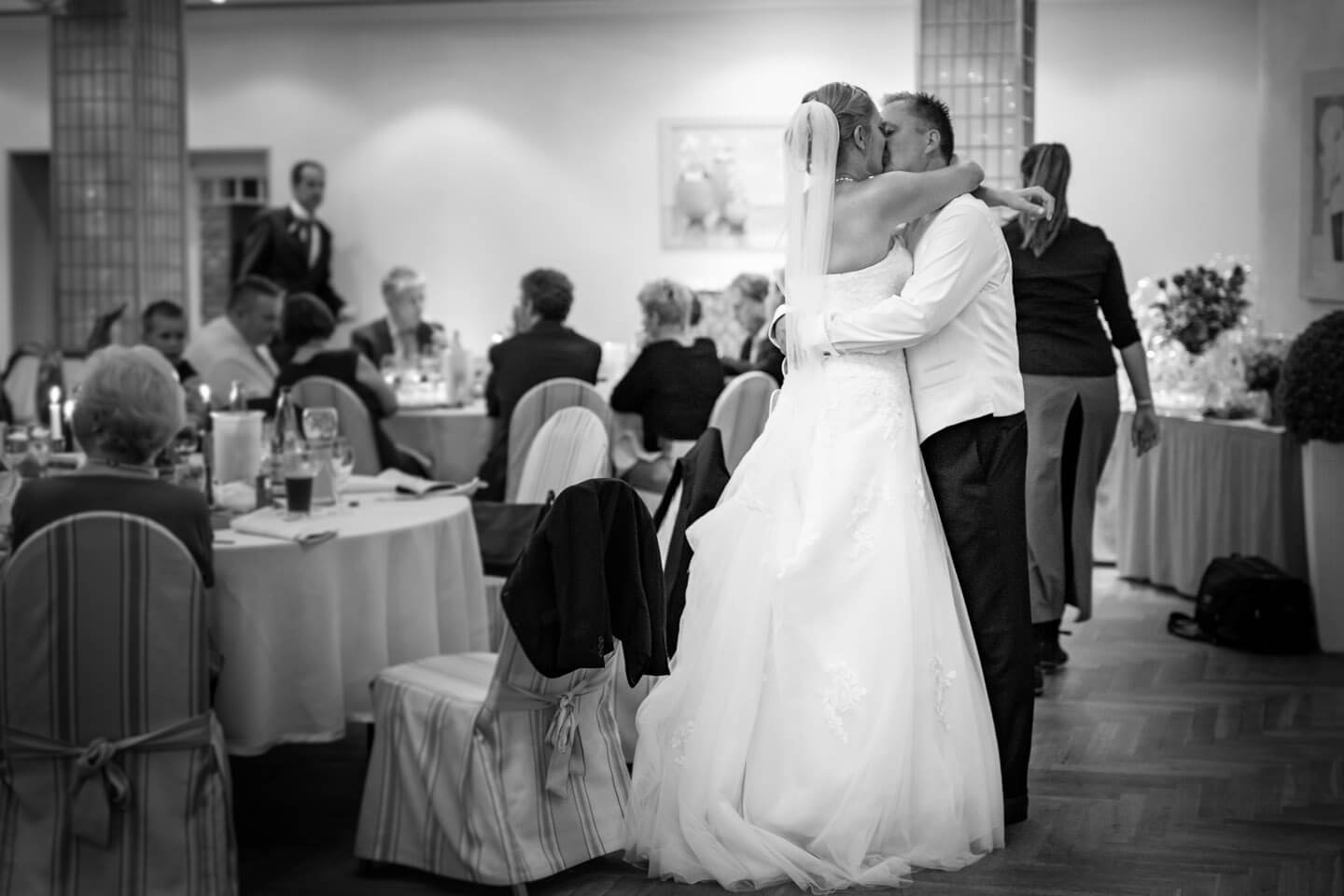 Hochzeitspaar kuesst sich auf ihrer Hochzeitsfeier