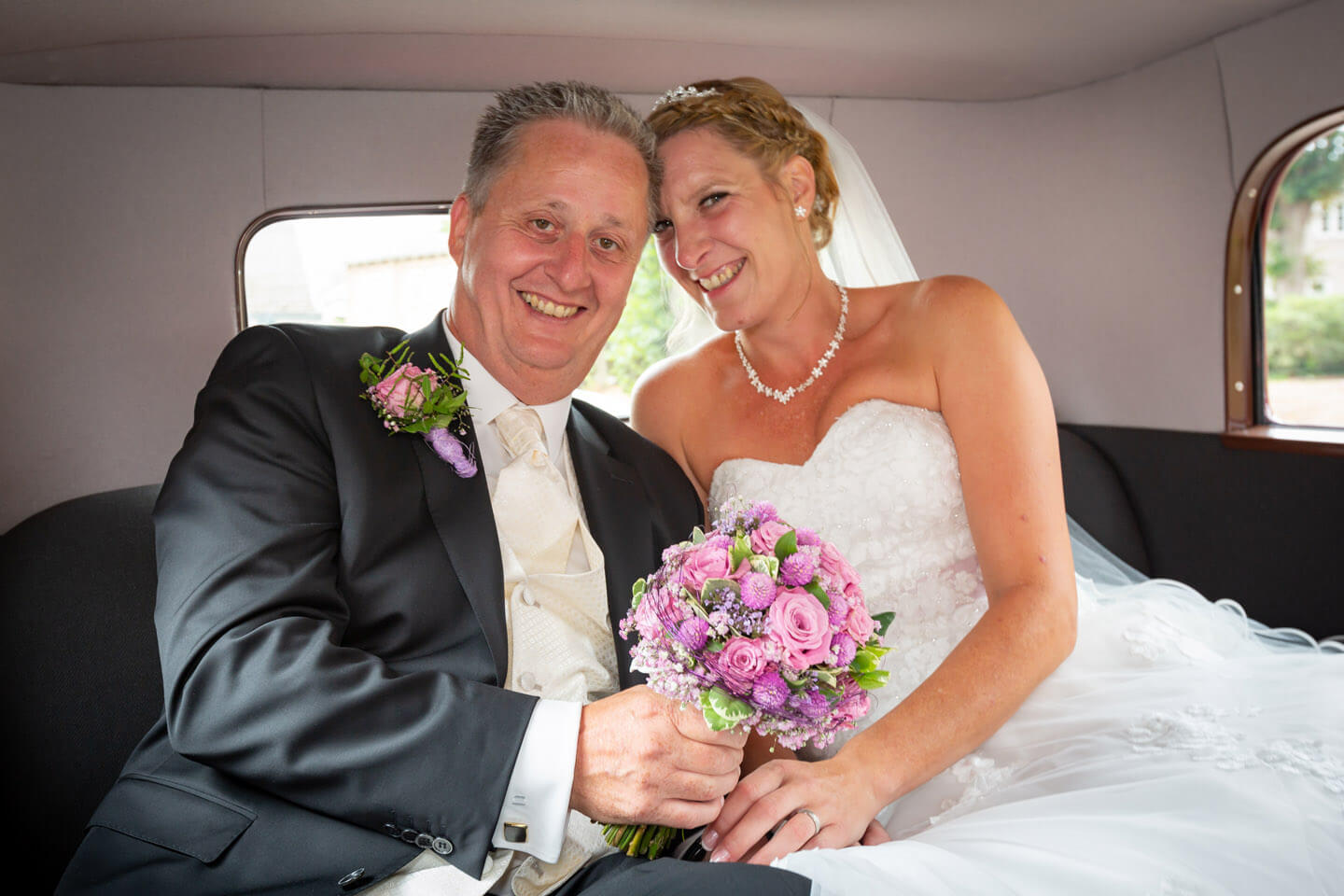 Hochzeitspaar im Hochzeitswagen