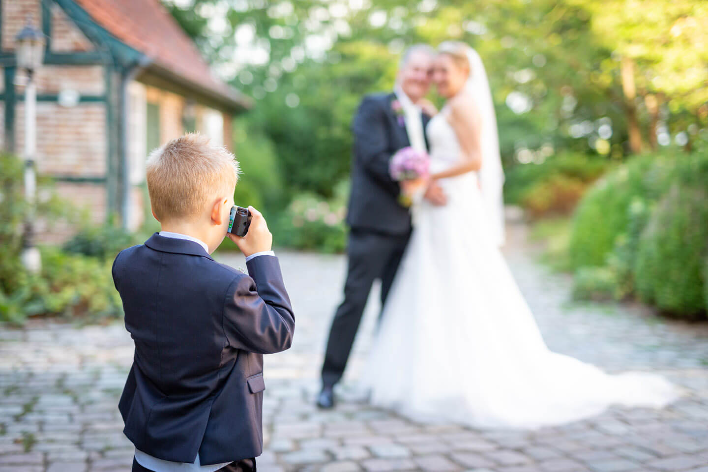 Kind fotografiert das Hochzeitspaar