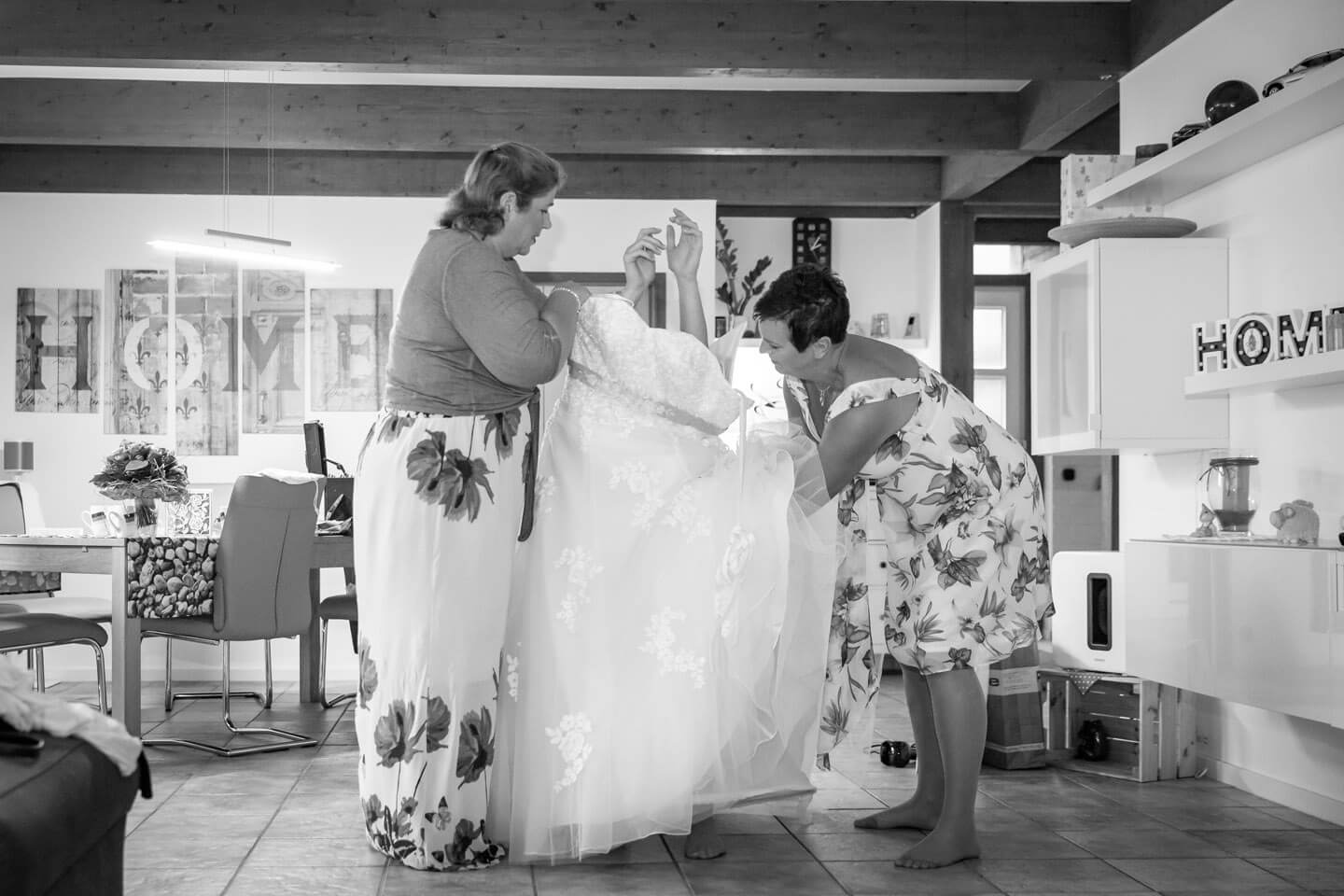 Braut schluepft bei einer Hochzeitsreportage ins Brautkleid