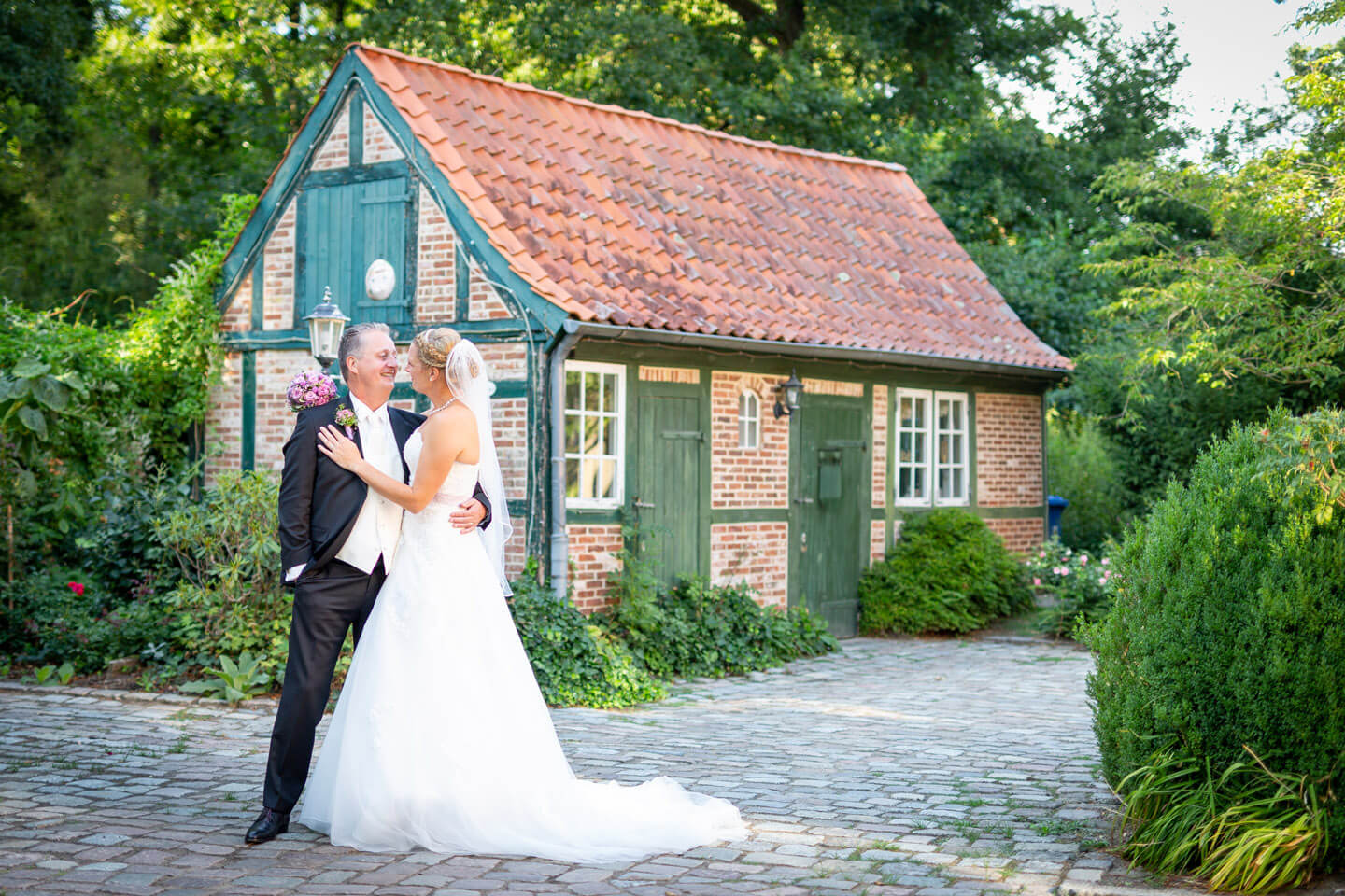 Hochzeitspaar vor kleinem Fachwerkhaus