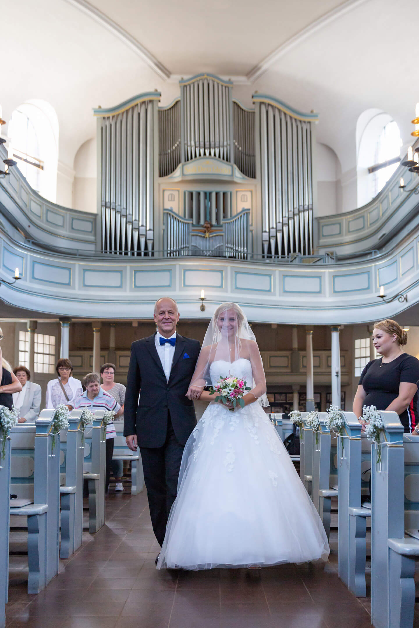 Braut wird vom Brautvater zum Altar geführt