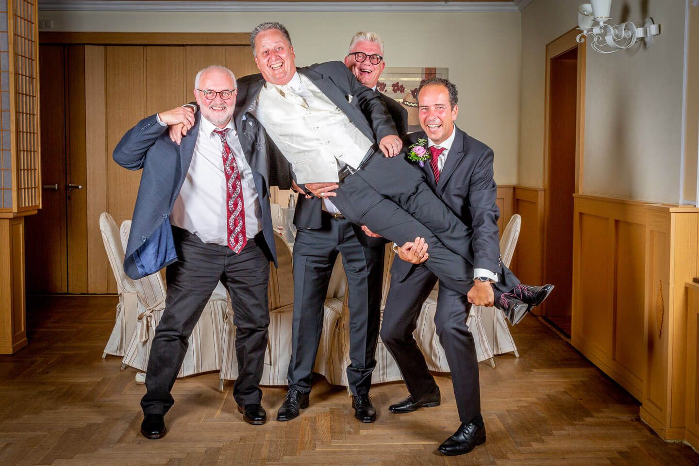 Braeutigam wird bei einer Hochzeitsreportage von seinen Jungs hochgehoben
