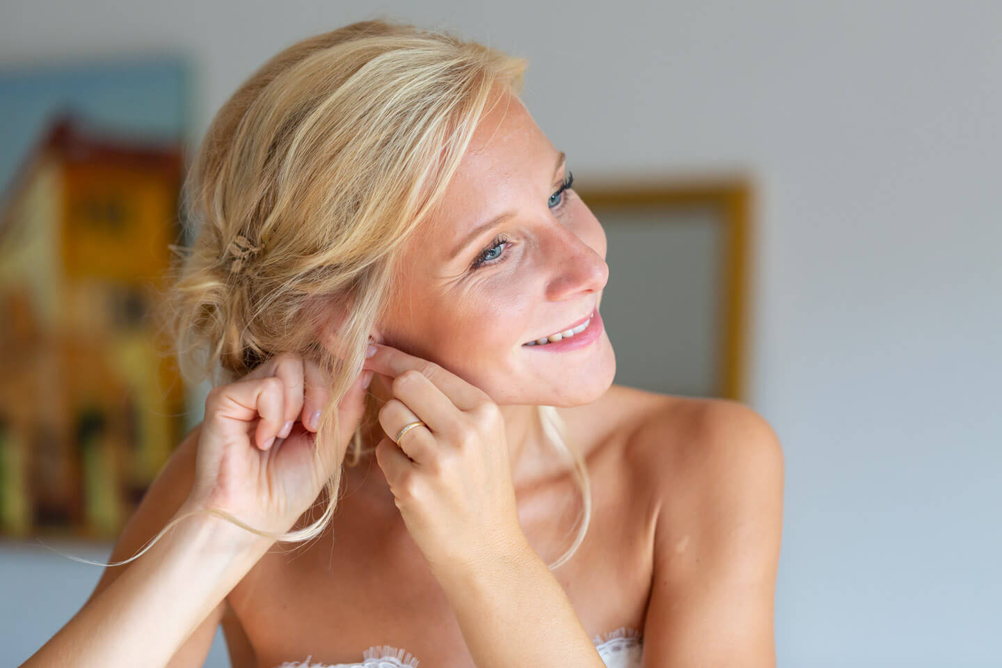 Braut steckt sich Ohrringe ein