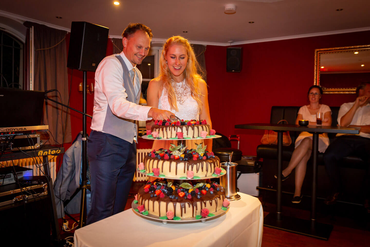 Anschnitt der Hochzeitstorte von Braut und Bräutigam