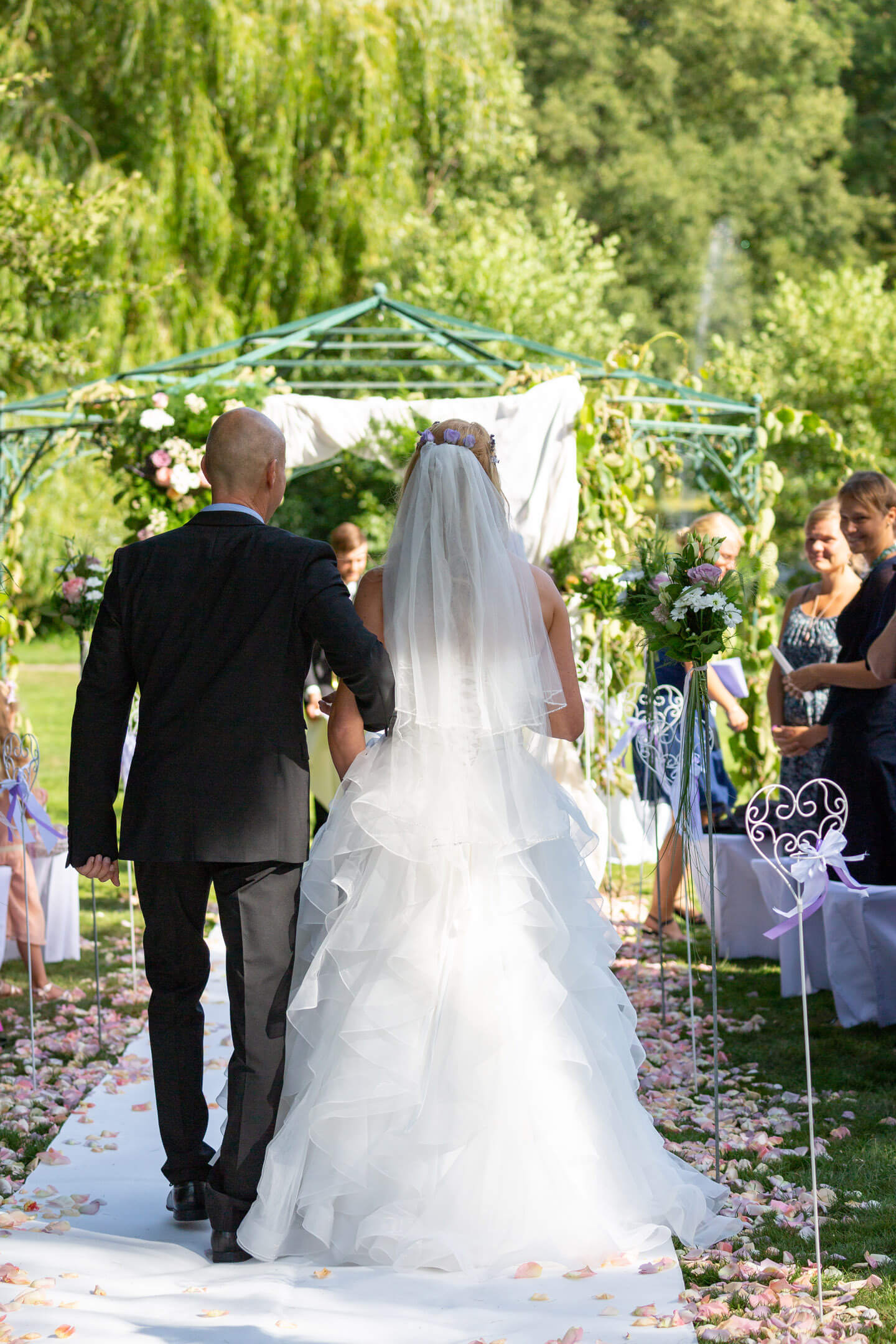 Braut wird von ihrem Papa zum Altar geführt