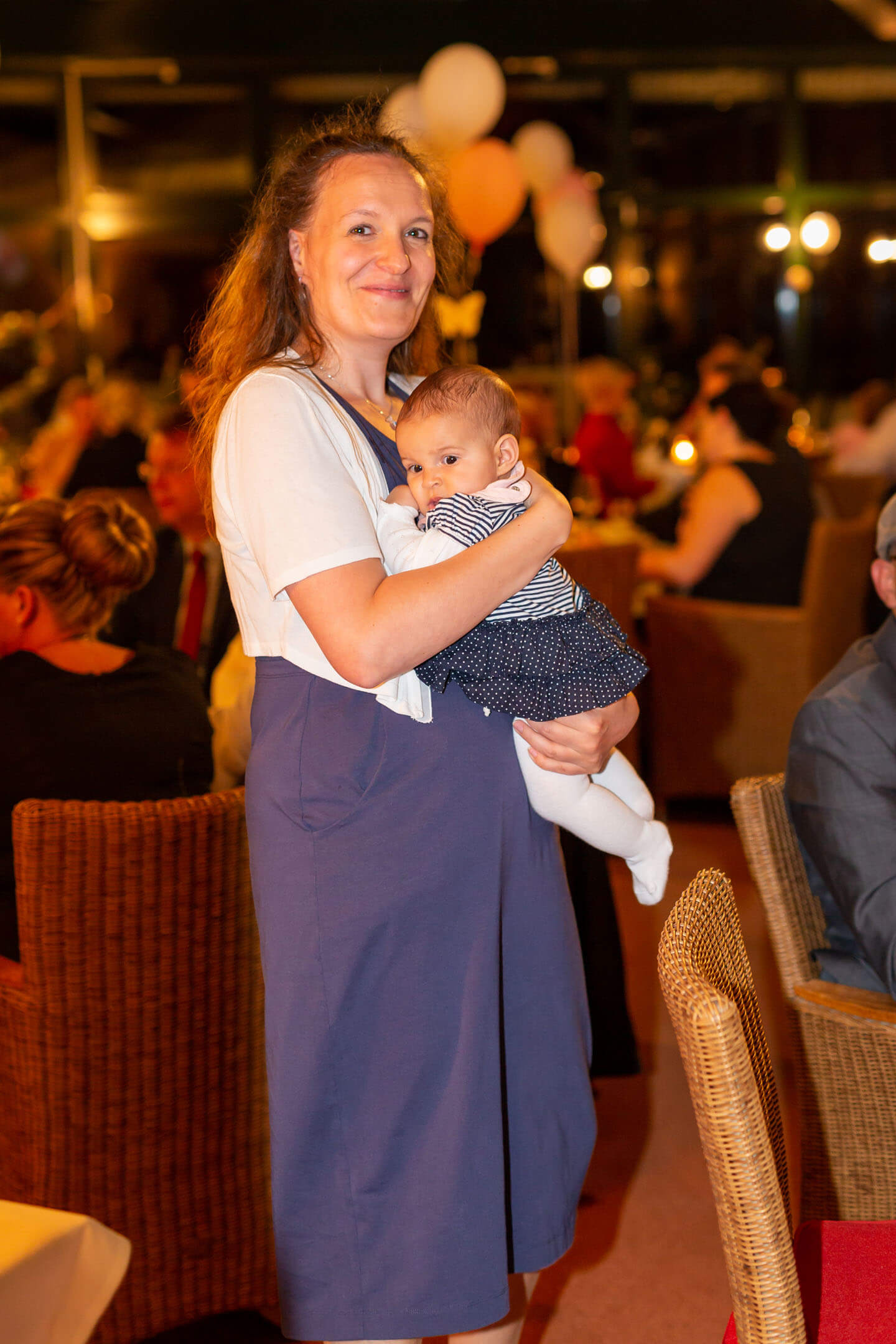 Mutter mit Neugeborenem auf Hochzeitsfeier