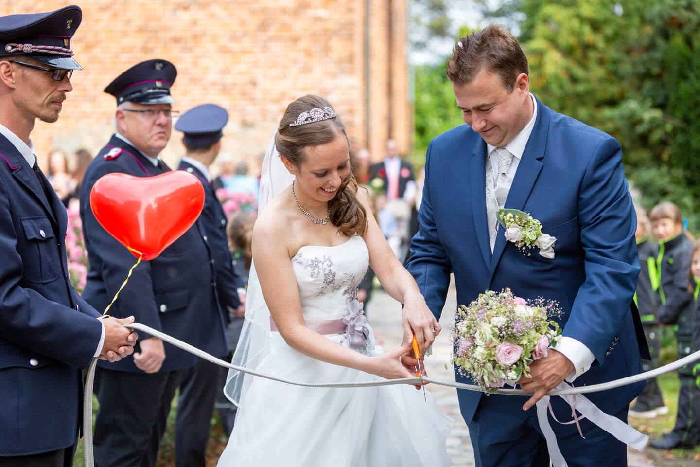 Brautpaar durchtrennt Feuerwehrschlauch