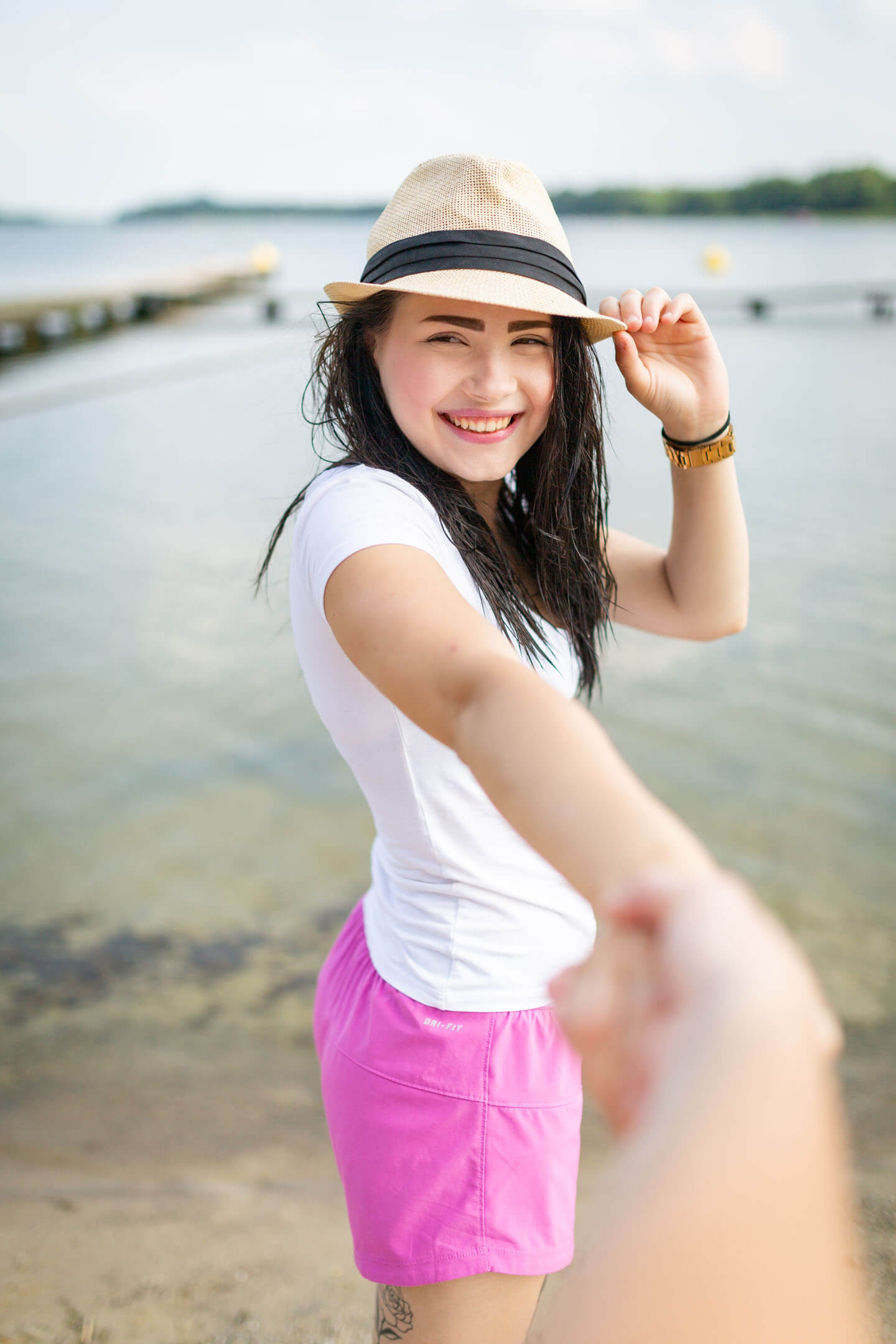 Outdoor-Portrait einer jungen Frau, die die Hand ihres Freundes hält