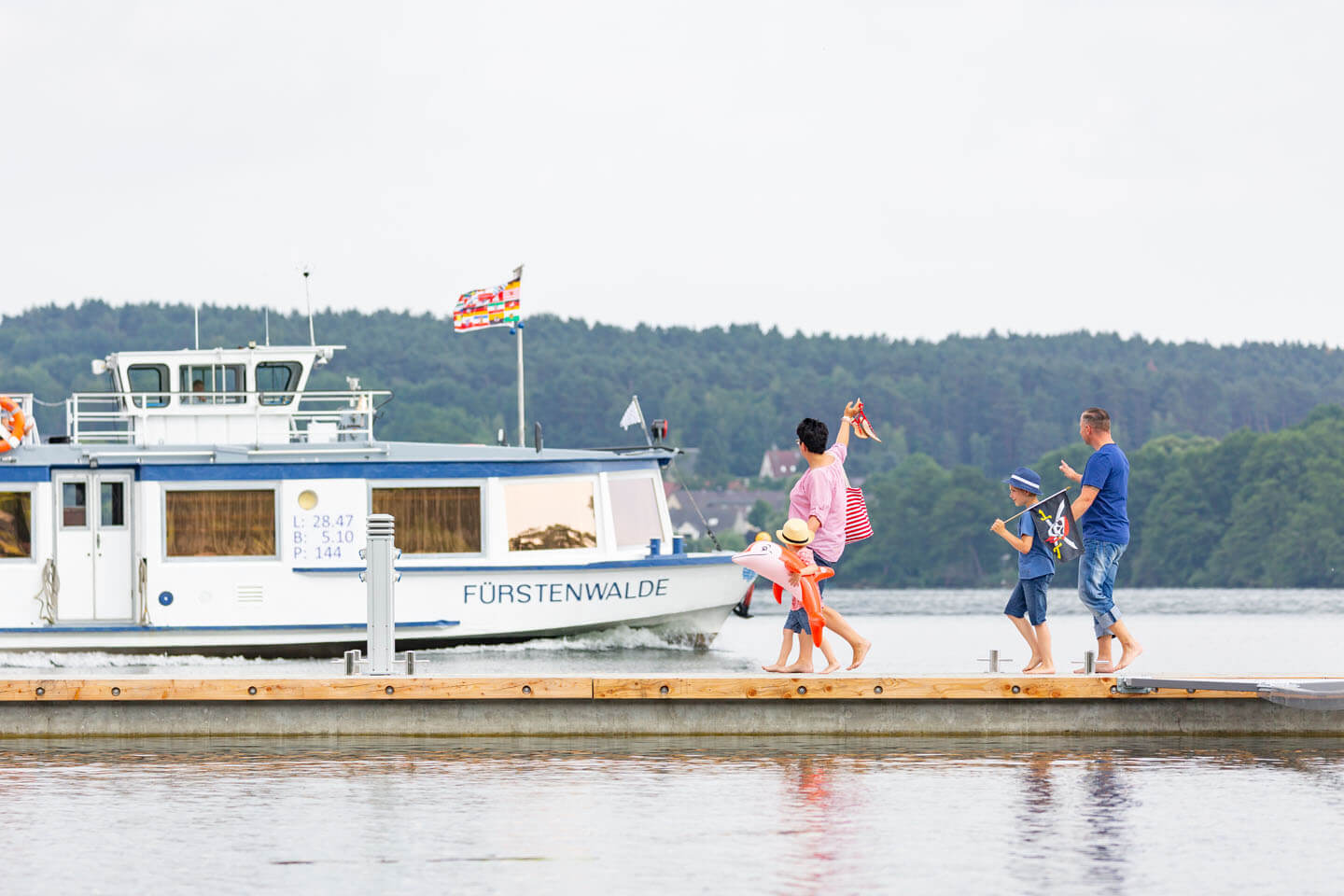 Familie winkt vom Steg aus einem Dampfer auf dem Scharmützelsee zu