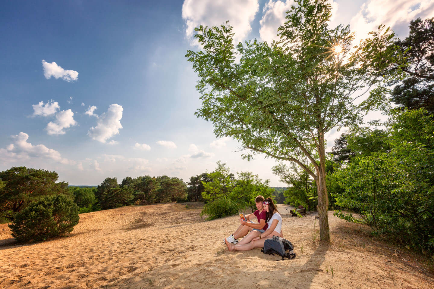 Paar sitzt auf Sandhügel in Brandenburg