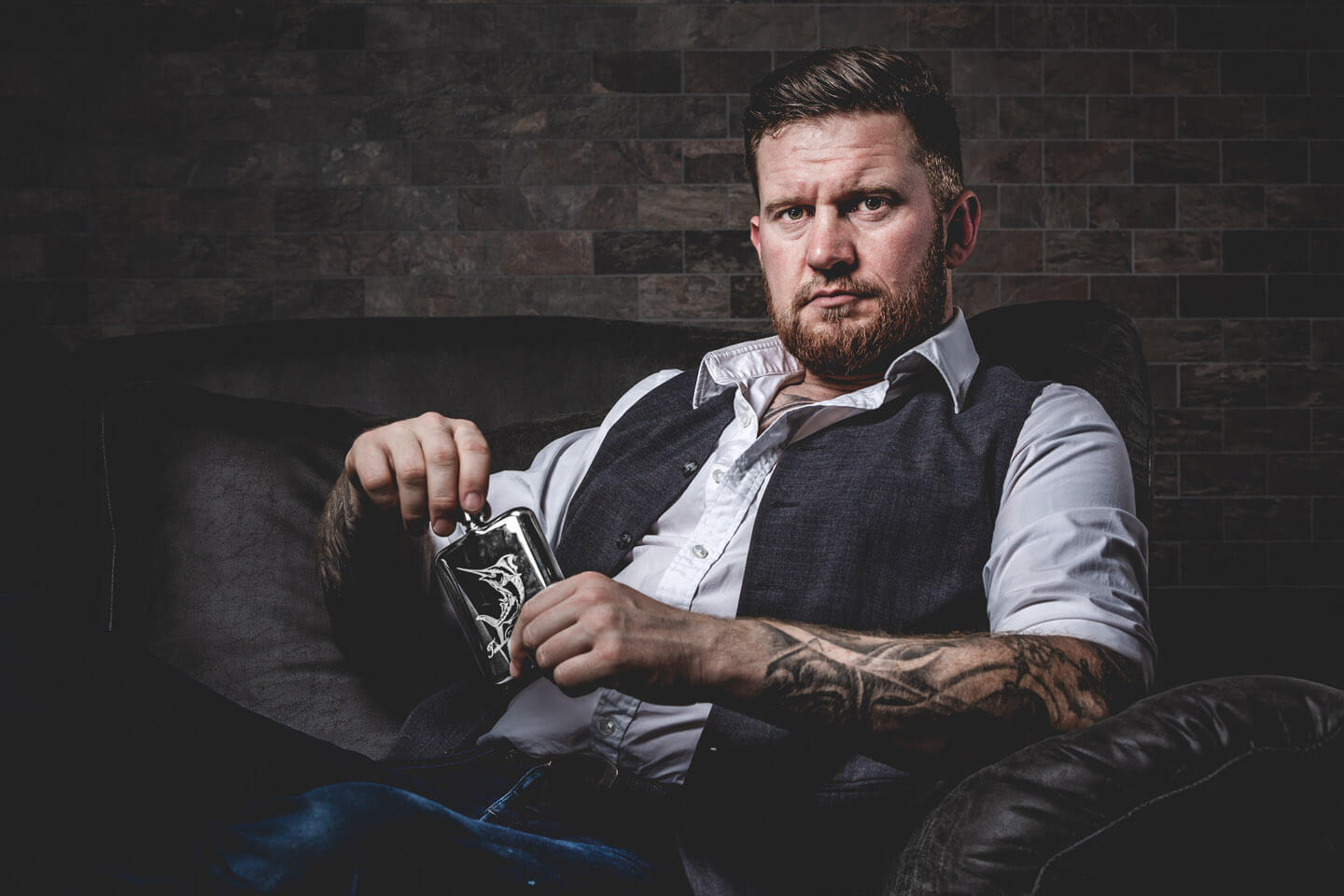 Portraitfoto bei wenig Beleuchtung. Mann im Sessel