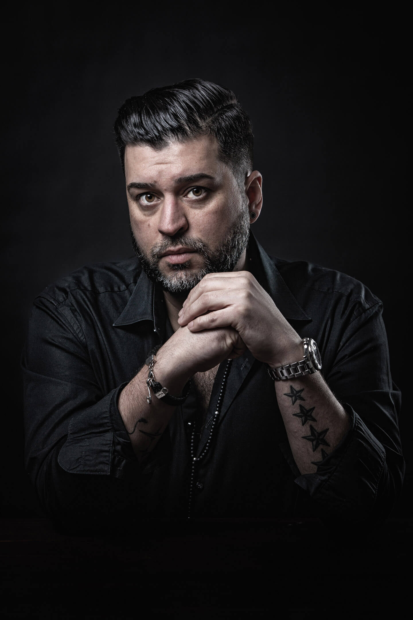 Foto (halb entsättigt) von dunkelhaarigem Mann bei schwachem Licht