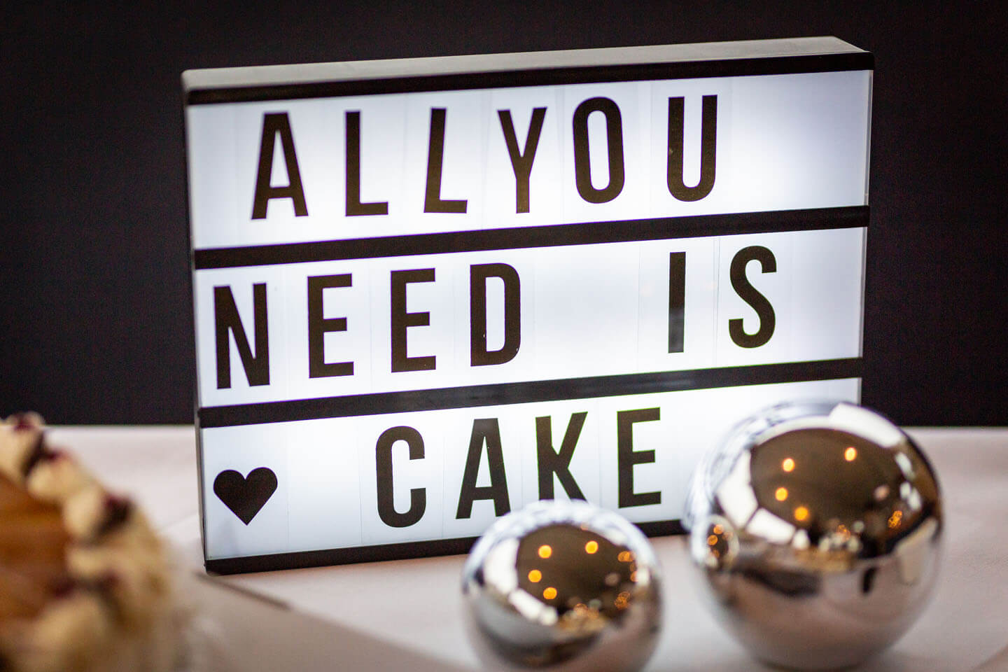 Leuchtschild "All you need is cake" auf Kuchenbüfett