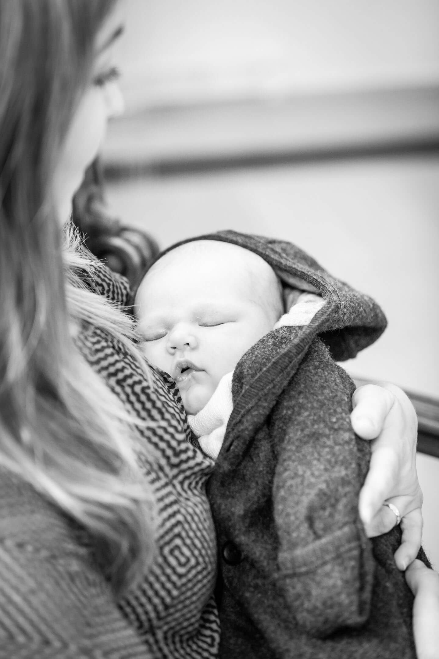 Neugeborenes schlafend im Arm