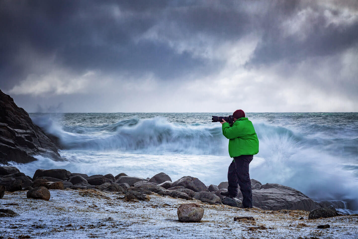 Fotograf vor brechenden Wellen auf den Lofoten