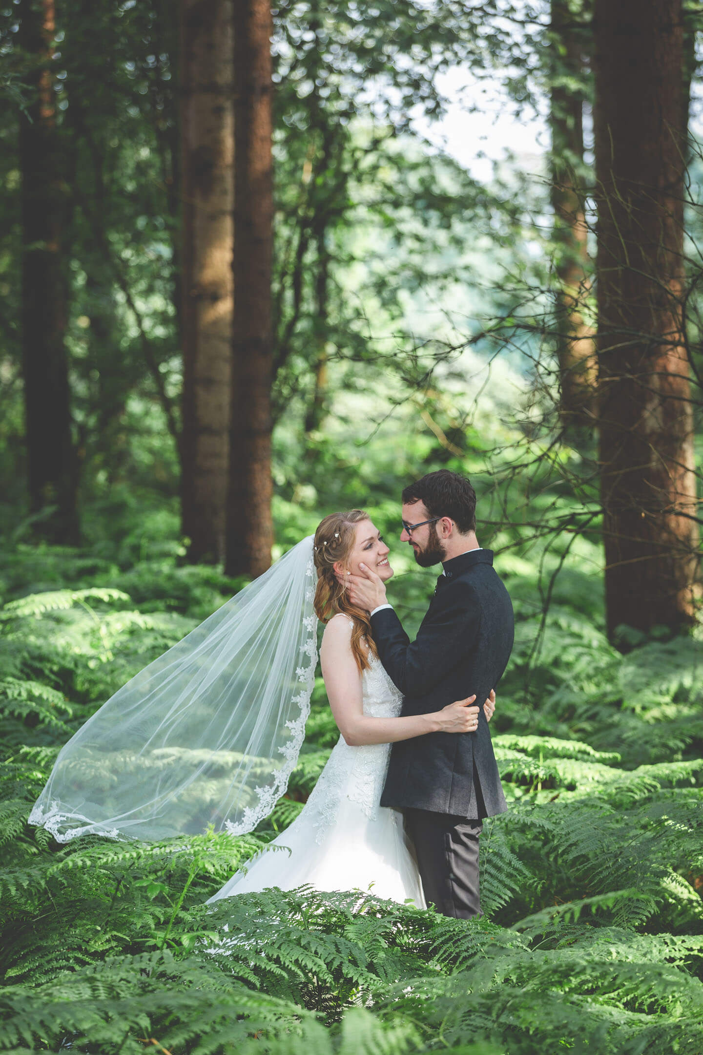 Hochzeitsfoto zwischen Farnen im Wald. Foto: Florian Läufer