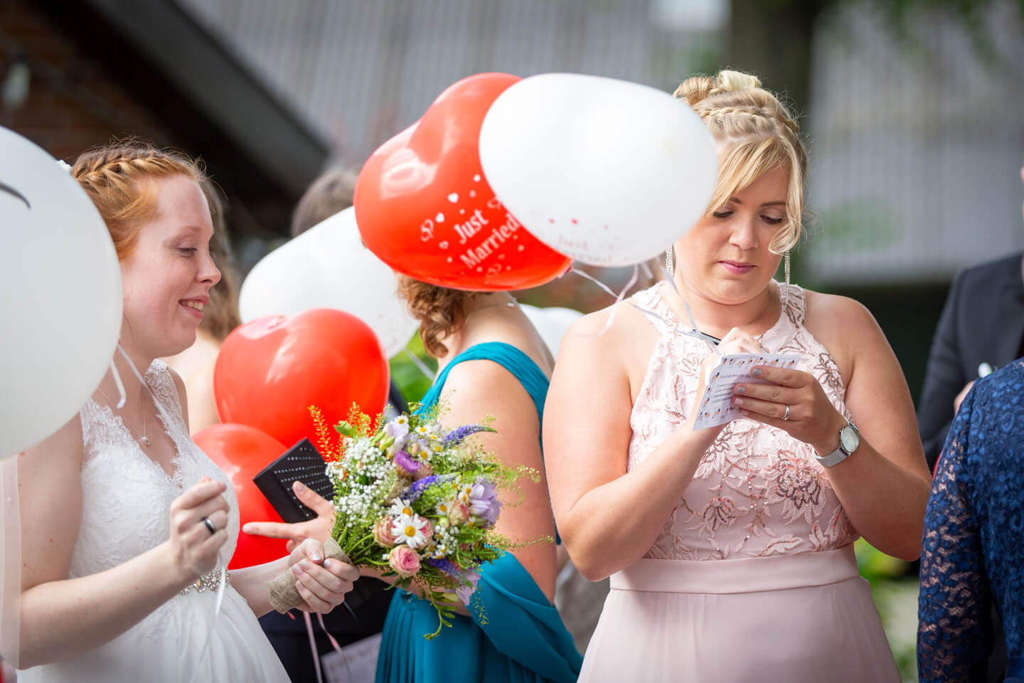 Hochzeitsgast schreibt einen Wunsch auf die Karte eines Heliumballons