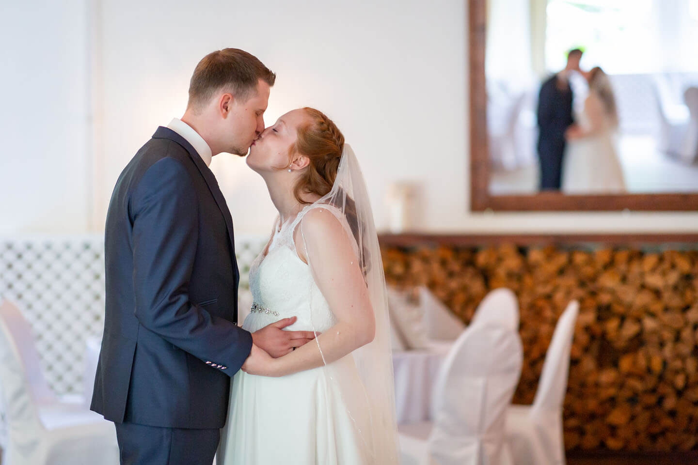 Brautpaar küsst sich und ist im Spiegel zu sehen.