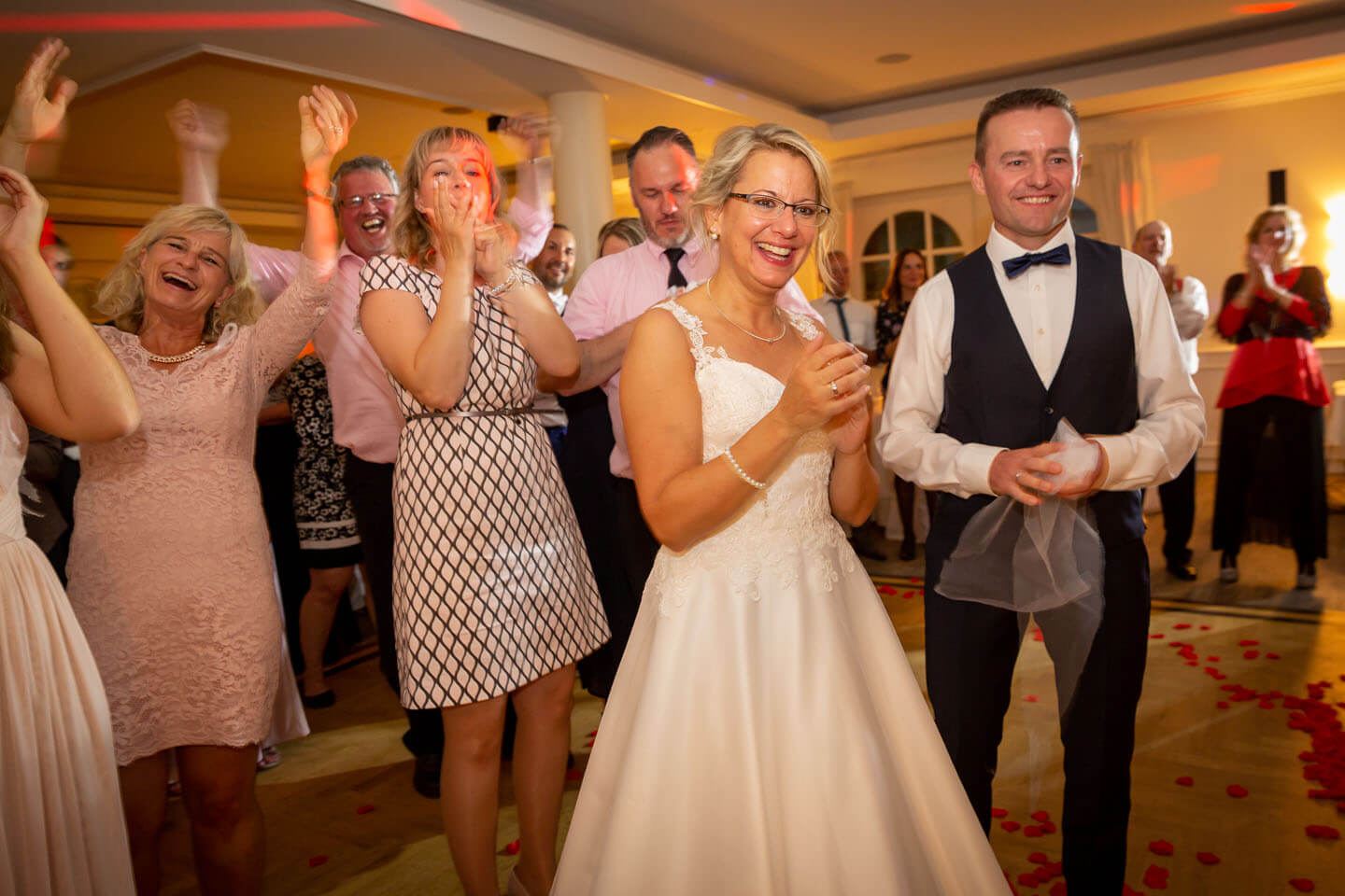 Hochzeitsgesellschaft klatscht beim hereinbringen der Hochzeitstorte