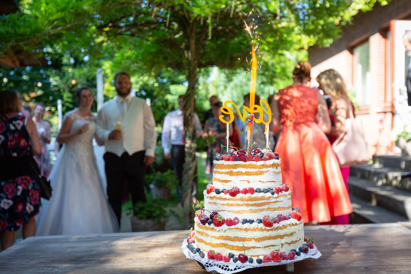 Hochzeitstorte mit Feuerwerk bei einer Sommerhochzeit im Landhaus-Stil