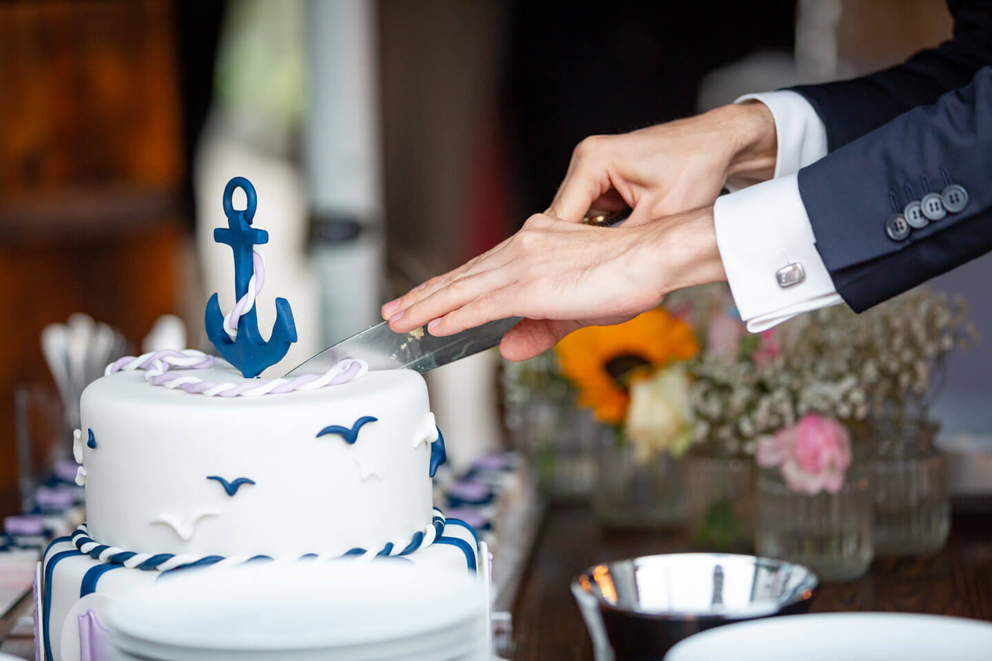 Anschnitt der Hochzeitstorte durch den Bräutigam