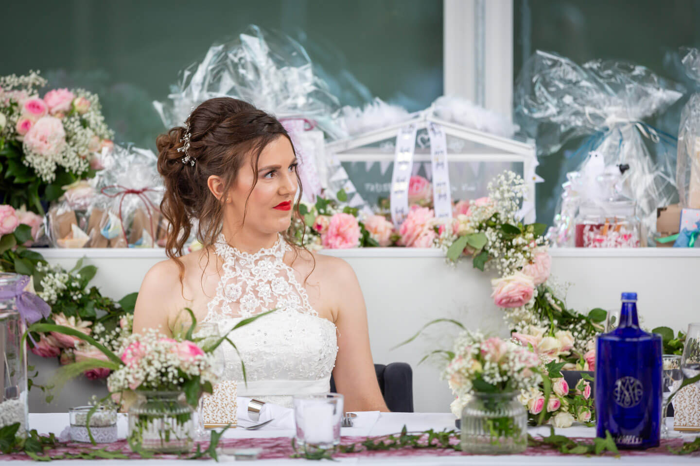 Braut sitzt inmitten einer liebevoll geschmückten Location
